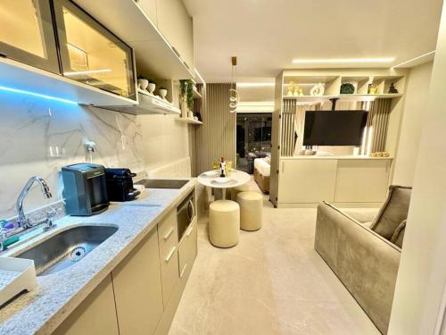 a kitchen with a sink and a living room at 405 - Rentaqui Apartamento The Prime Moema in Sao Paulo