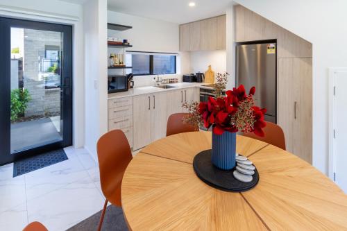 a kitchen with a table with a vase of flowers on it at Bright & Stylish 2BR Near Addington Park in Addington