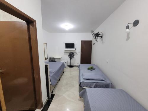 a hospital room with two beds and a door at Hospedaria São Benedito in Guararema
