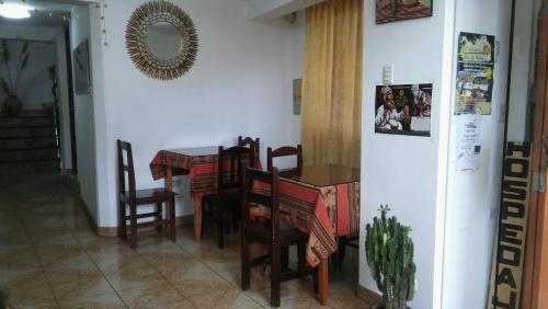 a dining room with a table and chairs and a mirror at Euro Hostal in Cusco