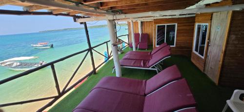 a group of purple chairs on a boat on the water at Ecohotelhector in Playa Blanca