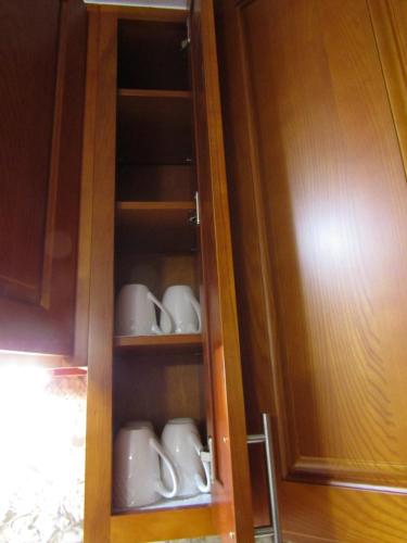 a cabinet filled with cups and saucers at Couple's Retreat - Get Away to Turtle Bay in Kahuku