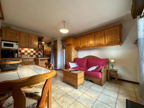 un salon avec un canapé rouge et une cuisine dans l'établissement Charmant studio rénové proche télécabine avec terrasse et parking - FR-1-642-96, à Morillon