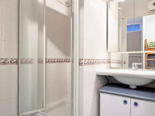 une salle de bain blanche avec une douche et un lavabo dans l'établissement Appartement 6 couchages à 100m plage avec terrasse, parking, lave-linge et piste cyclable proche - FR-1-251-550, au Lavandou