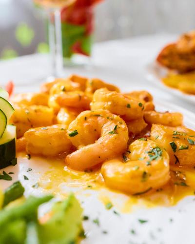 a plate of shrimp with a glass of wine at Hotel El Encanto in Cahuita