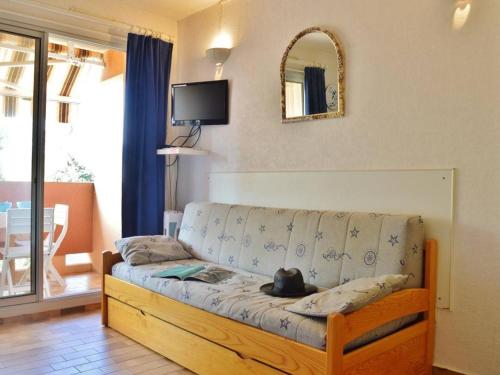 un salon avec un canapé et un miroir dans l'établissement Studio cabine 4 pers avec piscine, tennis et accès direct plage - Bormes-les-Mimosas - FR-1-251-559, à Bormes-les-Mimosas