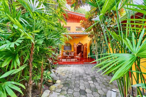 a courtyard of a house with palm trees at Hotel El Encanto in Cahuita
