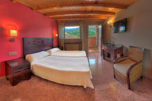 Un dormitorio con una cama grande y una silla. en Hotel Casa Custodio, en La Puebla de Roda