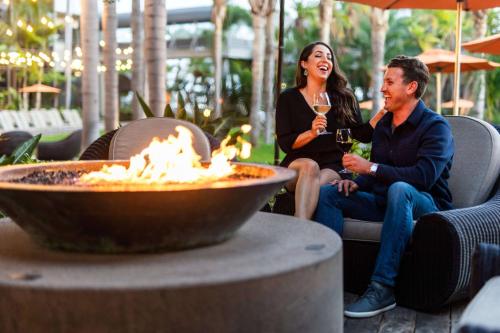 a man and woman sitting next to a fire pit at Marriott Marquis San Diego Marina in San Diego