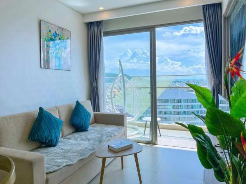 a living room with a couch and a large window at The Song Boutique Apartment in Vung Tau