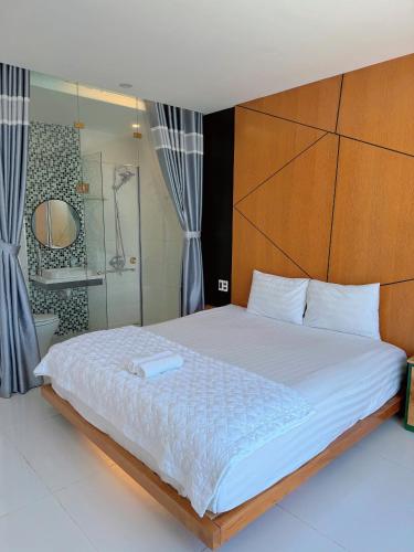 a bedroom with a large bed with a wooden headboard at Cen Hotel in Vung Tau