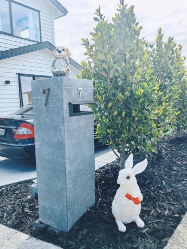 a statue of a rabbit sitting on top of a mailbox at Orewa New house with view on deck near Cafe,bush & river in Orewa
