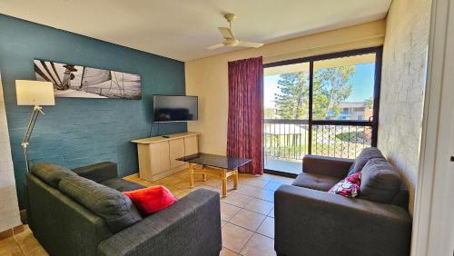 ein Wohnzimmer mit zwei Sofas und einem Fernseher in der Unterkunft Riverview Holiday Apartment 54 - Kalbarri WA in Kalbarri