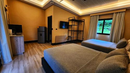a room with a bedroom with a bed and a television at Cabaña V Moderna y Memorable Corotú Garden in Boquete