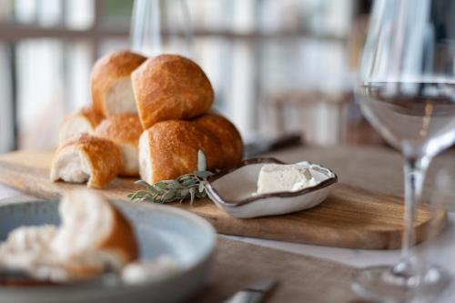a table with a plate of bread and a glass of wine at The River Suites, Kangaroo Island in American River