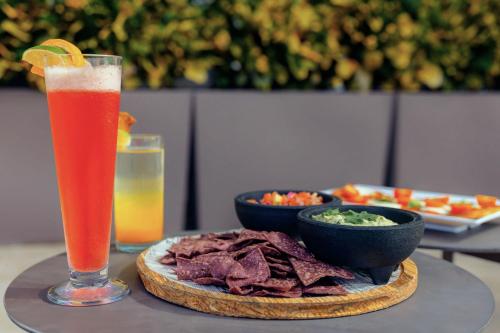 a table with a plate of food and a drink at Aloft San Juan in San Juan