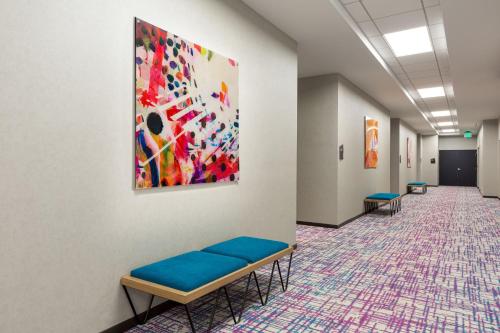 a waiting room with benches and a painting on the wall at Aloft San Juan in San Juan