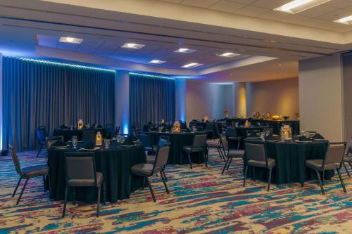 a banquet hall with tables and chairs and a room with blue curtains at Aloft San Juan in San Juan