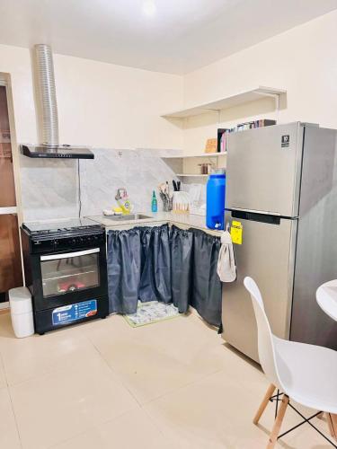 a kitchen with a refrigerator and a table with a stove at Asahel Cozy Crib Budget studio with Netflix in Buri