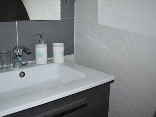 une salle de bain avec un lavabo blanc et un miroir dans l'établissement Charmant triplex ensoleillé à Font-Romeu - FR-1-580-122, à Font-Romeu-Odeillo-Via