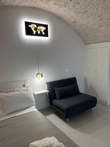 a bedroom with a bed and a blue chair at La Loggetta in Noci