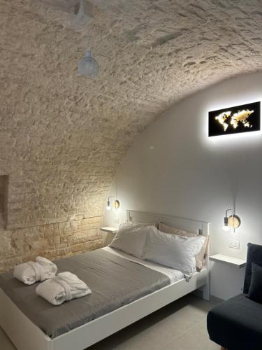 a bedroom with a bed and a stone wall at La Loggetta in Noci