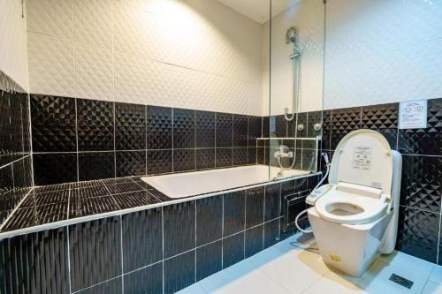 a bathroom with a toilet and a bath tub at Sakura Sky Residence in Bangkok