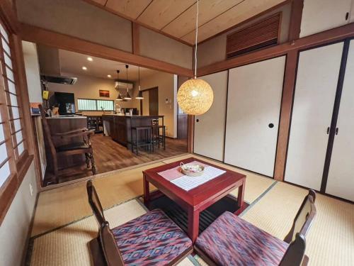 a living room with a table and chairs and a kitchen at Kamakura House in Kamakura