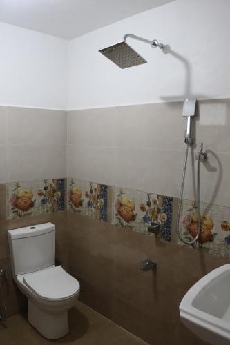 a bathroom with a white toilet and a sink at Relax Breath - Ratnapura in Ratnapura