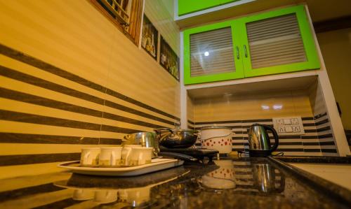 a kitchen with green cabinets and a counter top at S V IDEAL HOMESTAY -2BHK SERVICE APARTMENTS-AC Bedrooms, Premium Amities, 2KM to Tiruchanoor Padmavathi Temple , 6KM to Alipiri, 24 HOURS Service BOYS Available in Tirupati