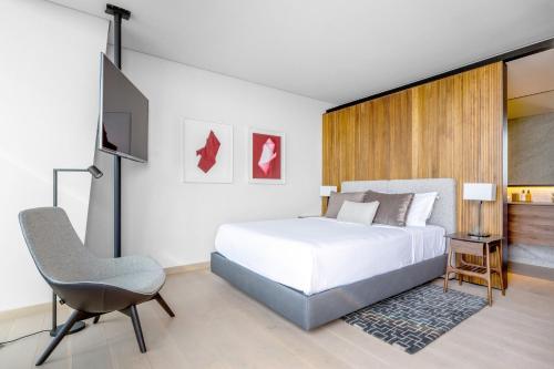 a bedroom with a white bed and a chair at The Ritz-Carlton, Mexico City in Mexico City