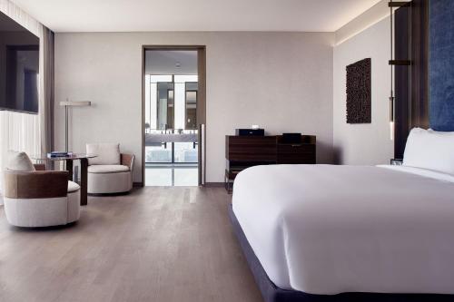 a bedroom with a large white bed and a chair at The Ritz-Carlton, Mexico City in Mexico City