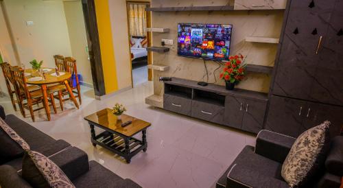 a living room with a couch and a tv at S V IDEAL HOMESTAY -2BHK SERVICE APARTMENTS-AC Bedrooms, Premium Amities, 2KM to Tiruchanoor Padmavathi Temple , 6KM to Alipiri, 24 HOURS Service BOYS Available in Tirupati
