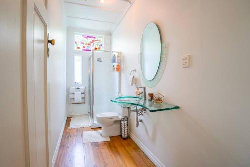 une salle de bain avec un lavabo en verre et des toilettes dans l'établissement Horse Club Retreat 3 Bedrooms, à Dairy Flat