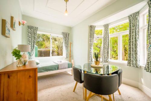 - une chambre avec un lit, une table en verre et des chaises dans l'établissement Horse Club Retreat 3 Bedrooms, à Dairy Flat