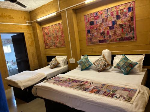 a room with two beds and a painting on the wall at Hotel Fotiya jaisalmer in Jaisalmer