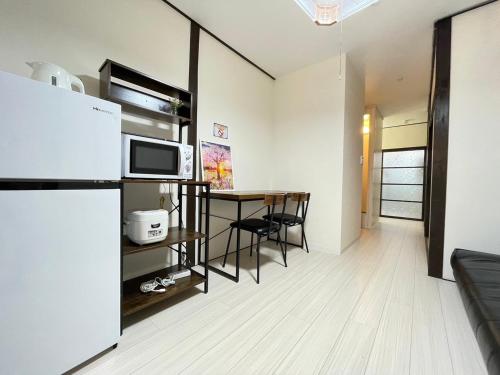 a kitchen and dining room with a table and a microwave at A&C House 新大阪 in Osaka