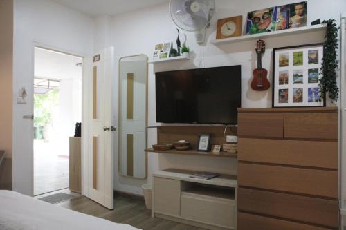 a bedroom with a flat screen tv on a wall at Homeku Guesthouse Room 2 near airport at Latkrabang in Lat Krabang