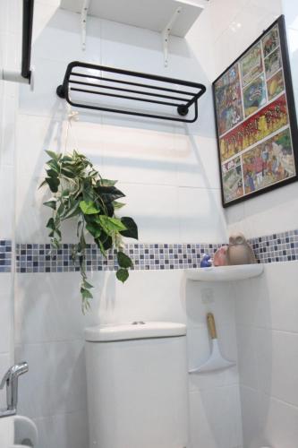 a bathroom with a toilet and a plant on the wall at Homeku Guesthouse Room 2 near airport at Latkrabang in Lat Krabang