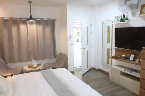 a bedroom with a bed and a flat screen tv at Homeku Guesthouse Room 2 near airport at Latkrabang in Lat Krabang