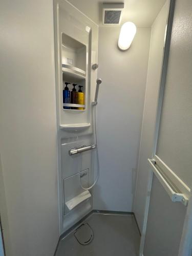 a bathroom with a refrigerator with drinks in it at A&C House 新大阪 in Osaka