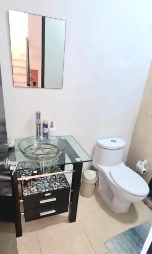 a bathroom with a toilet and a glass sink at Kaan Town Houses Cancún in Cancún