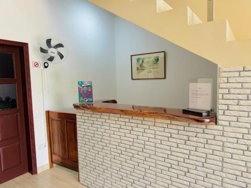 a brick fireplace in a room with a staircase at Bijoutier Apartments in Grand'Anse Praslin