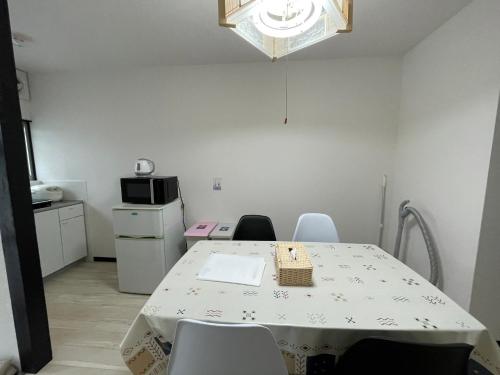 a kitchen with a table and chairs in a room at A&C House 新大阪 in Osaka