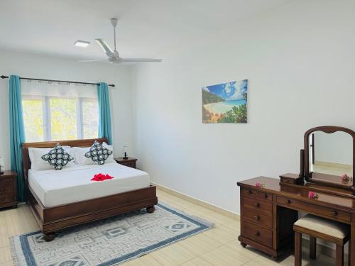 a bedroom with a bed and a dresser and a desk at Bijoutier Apartments in Grand'Anse Praslin