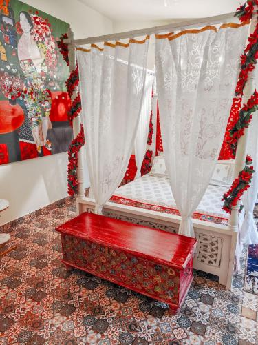 a room with a bed with a red trunk at CHATEAU MADEIRA BY GOAN DIARIES in Moira