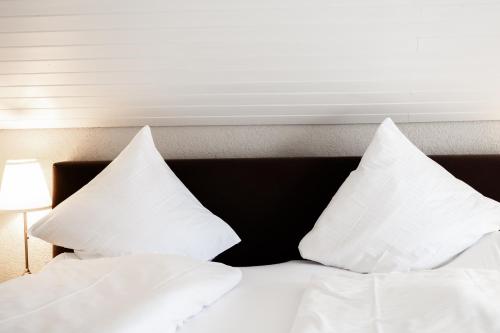 a bed with white pillows on top of it at Drei Könige in Entlebuch