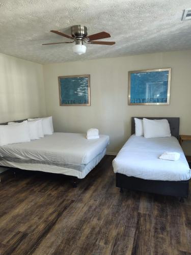 two beds in a room with a ceiling fan at The Delightful Doubles- Unit A- Centrally Located in Columbus