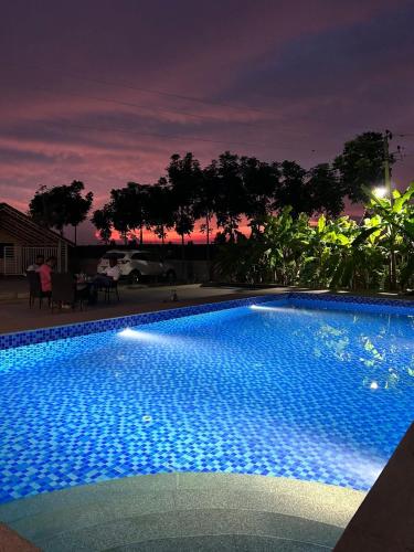 a large blue swimming pool at night at Echoes in Nandigunda