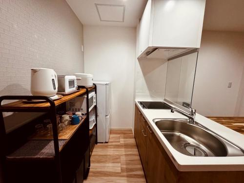 a small kitchen with a sink and a stove at Niseko Purr 101 in Kutchan